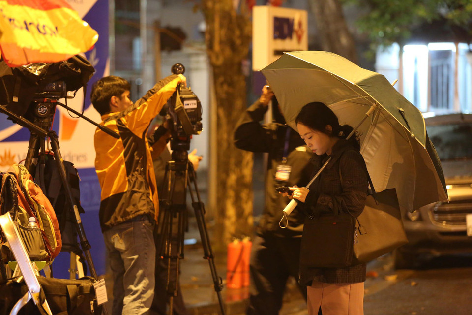 Mặc mưa rét, các nhà báo trong nước và quốc tế vẫn quyết tâm chờ đợi để có những khuôn hình đầu tiên về Chủ tịch Triều Tiên khi tới Hà Nội.(Ảnh: Minh Sơn/Vietnam+)