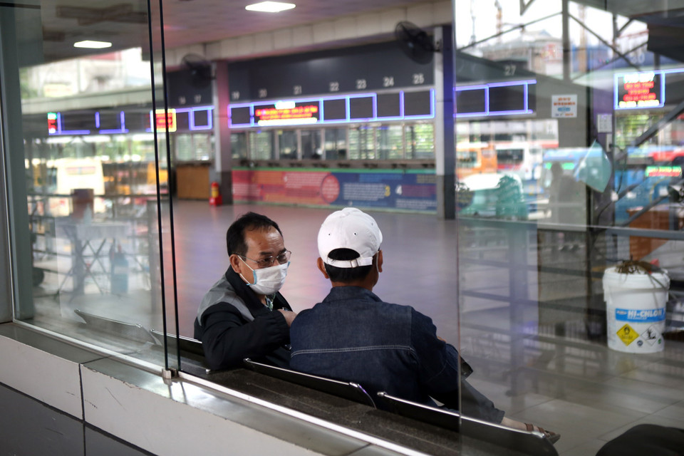 Hành khách đeo khẩu trang trong khi chờ xe tại bến xe Nước Ngầm(Hà Nội) . (Ảnh: Danh Lam/TTXVN)