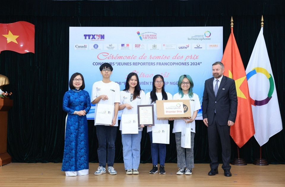 Phó Tổng giám đốc TTXVN Đoàn Thị Tuyết Nhung và Trưởng đại diện khu vực Châu Á-Thái Bình Dương của Tổ chức quốc tế Pháp ngữ Edgar Doerig trao giải Nhất cho nhóm thí sinh với tác phẩm "JT HANUvelles, cuộc phiêu lưu Pháp ngữ đầy sáng tạo". (Ảnh: Tuấn Anh/TTXVN)
