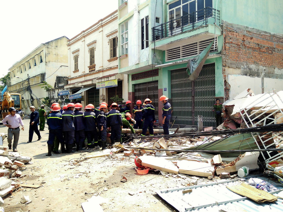 Lực lượng cứu hộ cứu nạn đang xử lý hiện trường vụ sập nhà. (Ảnh: Nguyên Linh/TTXVN)
