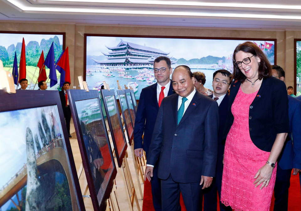 Thủ tướng Nguyễn Xuân Phúc, Bộ trưởng Bộ Môi trường kinh doanh, Thương mại và doanh nghiệp Romania, Đại diện Hội đồng EU Stefan-Radu Oprea và bà Cecilia Malmetrom, Cao ủy Thương mại EU xem trưng bày ảnh của TTXVN. (Ảnh: Thống Nhất/TTXVN)