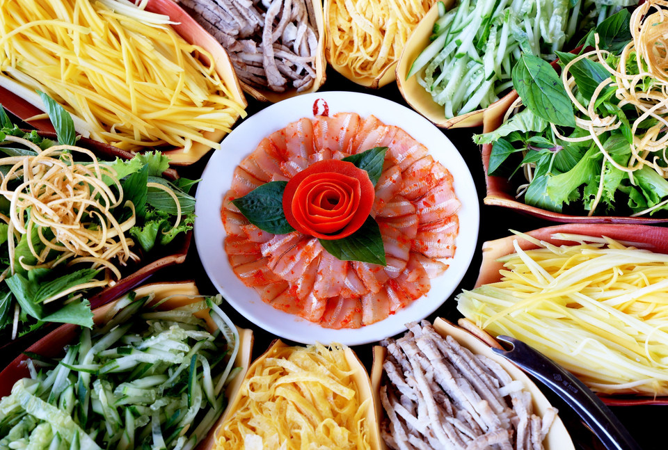 Các loại thức ăn kèm Lẩu Thả được xếp như một bông hoa trên mẹt lót lá chuối thể hiện tính dân dã. (Ảnh: Hồng Đạt/TTXVN)