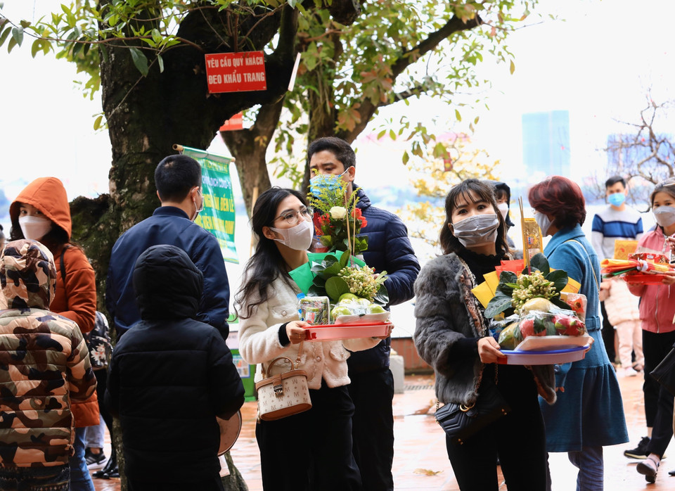 Nhiều người thành tâm chuẩn bị lễ vật khi vào lễ tại Phủ Tây Hồ (ảnh chụp ngày 13/2/2022 tức 13 tháng Giêng năm Nhâm Dần). (Ảnh: Hoàng Hiếu/TTXVN)