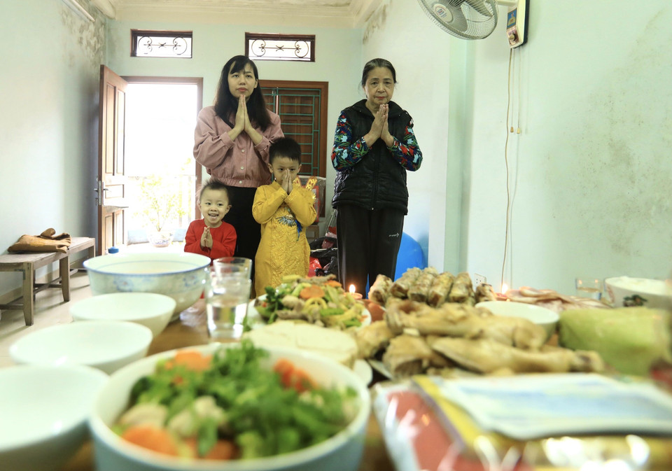 Gia chủ thành tâm khấn vái tiễn ông Công ông Táo, mong một năm mới bình an, thịnh vượng. (Ảnh: Hoàng Hiếu/TTXVN)