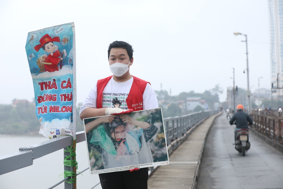 Tại khu vực cầu Long Biên, các tình nguyện viên tham gia hỗ trợ người dân thả cá, gom rác để xử lý. (Ảnh: Minh Quyết/TTXVN)