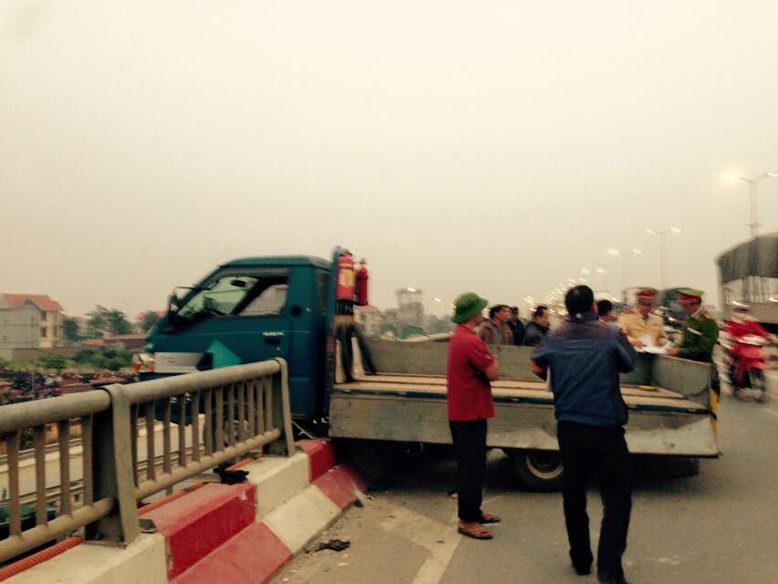 Đầu xe tải húc bay tiếp thanh thép chắn cầu, nhô hẳn ra bên ngoài. (Ảnh: Sơn Bách/Vietnam+)