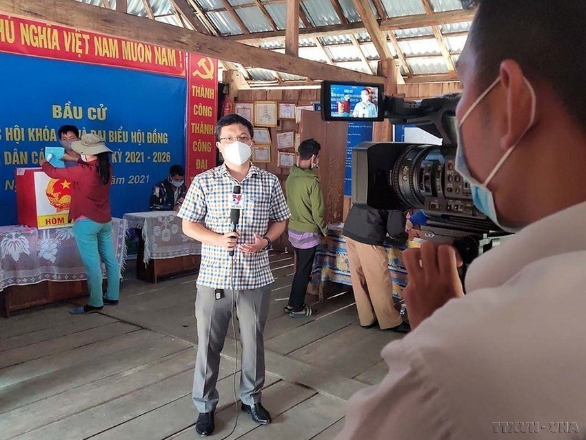 Trưởng cơ quan thường trú TTXVN tại tỉnh Kon Tum Hoàng Cao Nguyên và phóng viên Khoa Chương đưa tin bầu cử sớm tại điểm bầu cử số 3, thôn Măng Khênh, xã Đăk Man, huyện Đăk Glei, tỉnh Kon Tum (2021). (Nguồn: TTXVN)