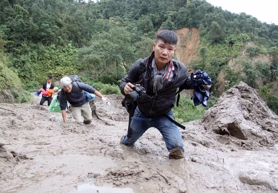Phóng viên Quý Trung của TTXVN cùng đồng nghiệp trên đường đi đưa tin lũ lụt ở Lai Châu, tháng 8/2018. (Nguồn: TTXVN)
