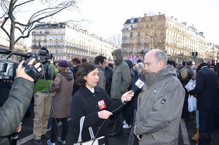 Nhà báo Phạm Bích Hà, Trưởng Cơ quan thường trú Thông tấn xã Việt Nam tại Paris (Pháp) phỏng vấn người dân tham gia cuộc tuần hành lịch sử phản đối khủng bố tại Paris, ngày 11/1/2015. (Nguồn: TTXVN)