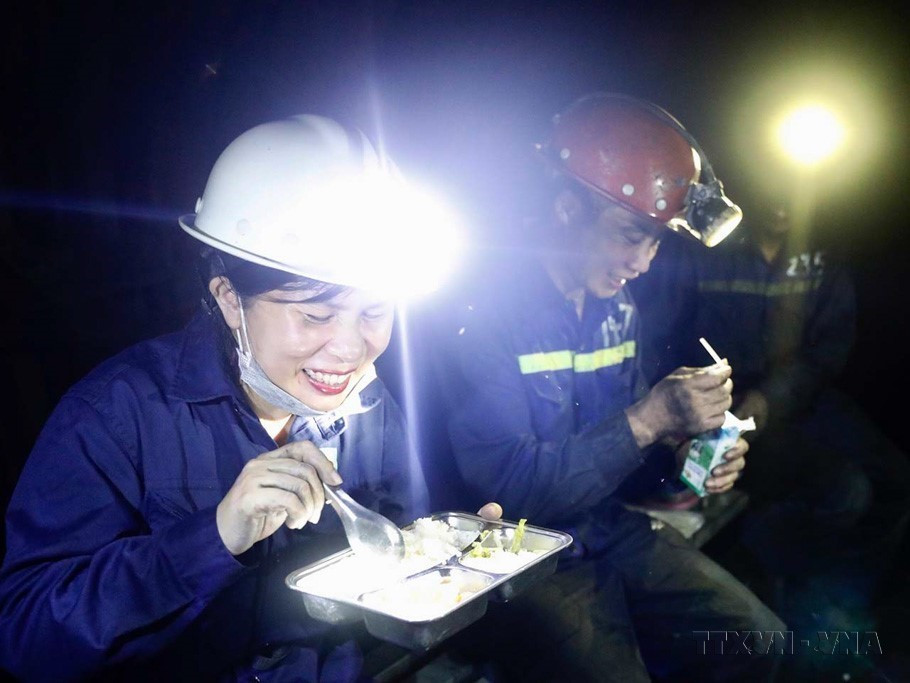 Phóng viên Thảo Nguyên của Thông tấn xã Việt Nam và bữa cơm trưa muộn cùng thợ mỏ dưới hầm lò. (Ảnh: TTXVN)