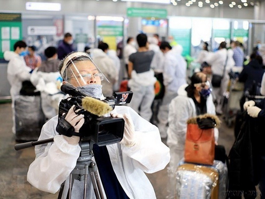 Trưởng Cơ quan thường trú TTXVN tại Moskva Bùi Duy Trinh đưa tin về chuyến bay đầu tiên đưa hơn 300 công dân Việt Nam từ Liên bang Nga về nước trong bối cảnh đại dịch COVID-19, tại sân bay Sheremetyevo (5/2020). (Nguồn: TTXVN)