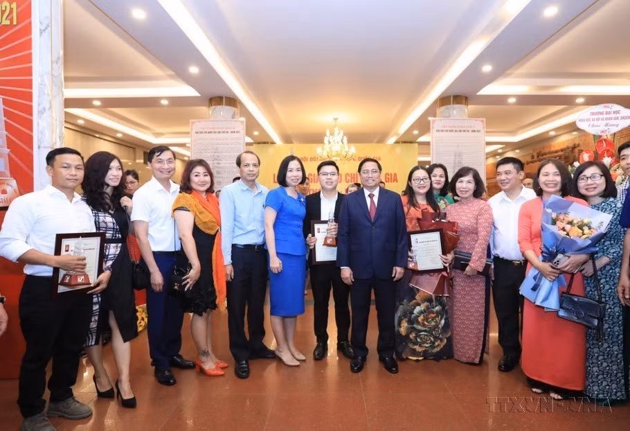 Thủ tướng Phạm Minh Chính, Tổng Giám đốc TTXVN Vũ Việt Trang cùng các tác giả, nhóm tác giả của Thông tấn xã Việt Nam đoạt giải Báo chí Quốc gia lần thứ 16 năm 2021. (Nguồn: TTXVN)