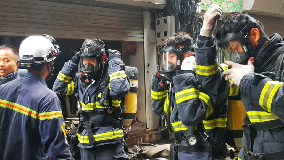 Các cán bộ chiến sỹ PCCC mặc trang bị bảo hộ để chuẩn bị tiếp cận hiện trường đám cháy. (Ảnh: Tuấn Anh/TTXVN)