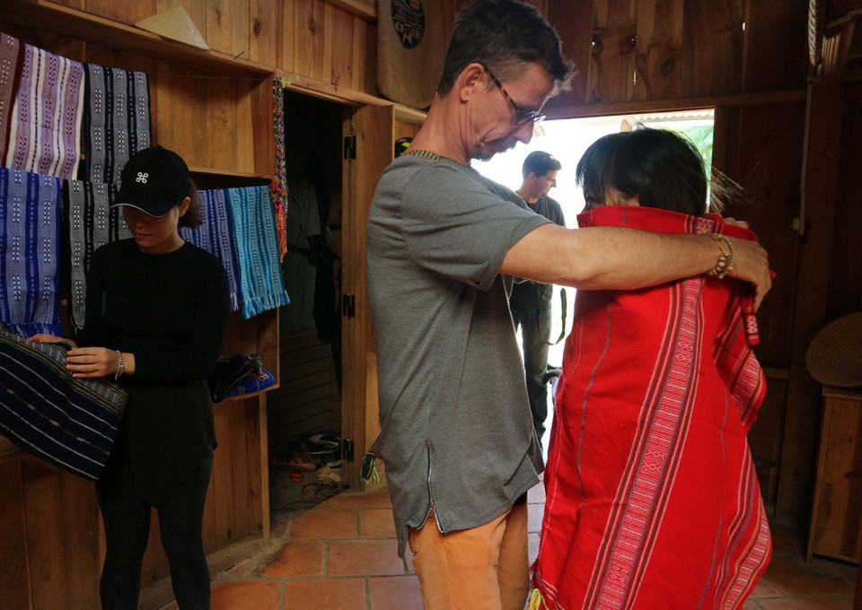 Du khách ướm thử vải thổ cẩm - sản phẩm dệt truyền thống của dân tộc K'Ho huyện Lạc Dương. (Ảnh: Nguyễn Dũng/TTXVN)