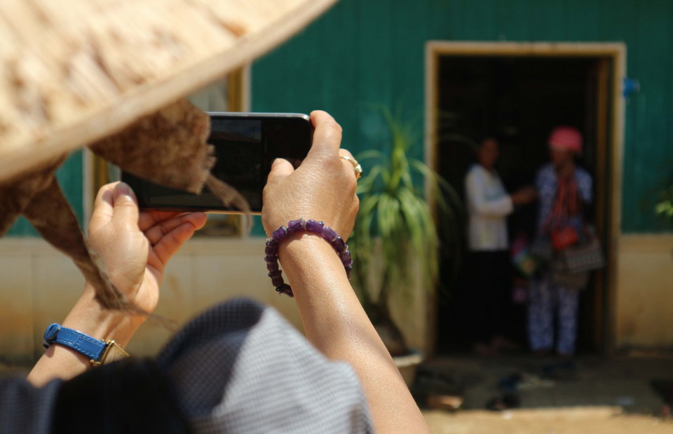 Du khách lưu giữ hình ảnh trên điện thoại những khoảnh khắc được trải nghiệm ở buôn làng. (Ảnh: Nguyễn Dũng/TTXVN)