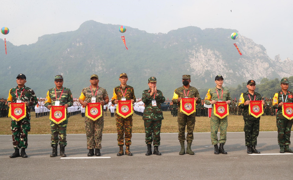  Tham gia có 420 tuyển thủ của 10 quốc gia trong khu vực thi đấu 5 môn gồm súng máy, súng trường, súng cabin, súng ngắn nam, súng ngắn nữ, mỗi loại súng hai bài. Trong ảnh: Ban tổ chức trao cờ lưu niệm cho các đoàn tham gia giải. (Ảnh: Trọng Đức/TTXVN)