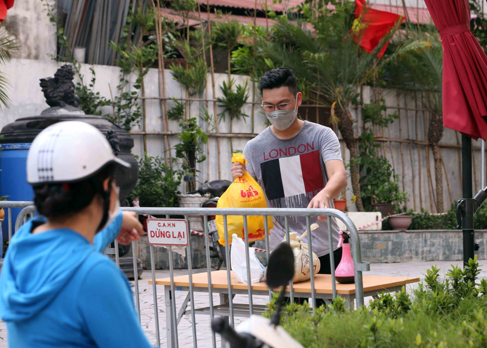 Người thân đưa đồ nhu yếu phẩm thiết yếu tiếp tế cho cư dân sống tại Toà chung cư Viễn Đông Star (số 1 phố Giáp Nhị, quận Hoàng Mai, Hà Nội) bị phong tỏa. (Ảnh: Phạm Kiên/TTXVN)