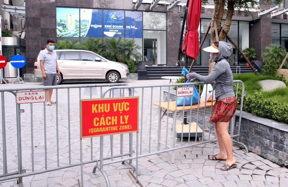 Người thân đưa đồ nhu yếu phẩm thiết yếu tiếp tế cho cư dân sống tại Toà chung cư Viễn Đông Star (số 1 phố Giáp Nhị, quận Hoàng Mai, Hà Nội) bị phong tỏa. (Ảnh: Phạm Kiên/TTXVN)