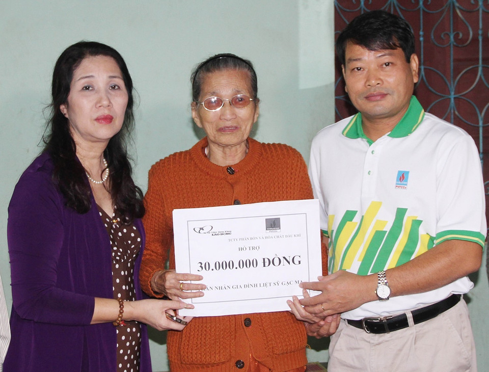 Đại diện Liên đoàn Lao động tỉnh Quảng Trị và Quỹ từ thiện xã hội Tấm lòng Vàng (Báo Lao động) trao số tiền hỗ trợ cho bà Trần Thị Giỏ, trú tại thành phố Đông Hà, là mẹ của liệt sỹ Tống Sỹ Bái hy sinh trong trận chiến đấu bảo vệ chủ quyền biển đảo Tổ quốc ở Gạc Ma năm 1988. (Ảnh: Hồ Cầu/TTXVN)