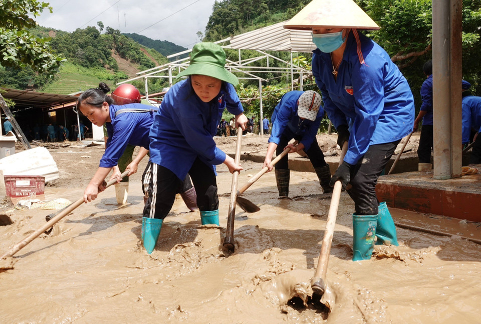 Lực lượng đoàn thanh niên và công an tham gia dọn dẹp bùn đất tại trường Phổ Thông dân tộc bán trú Tiểu học và Trung học Cơ sở xã Hồ Bốn. (Ảnh: Tuấn Anh/TTXVN)