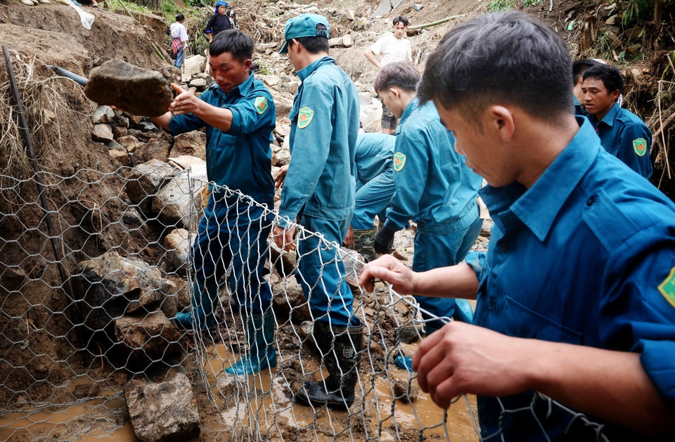 Lực lượng dân quân các xã và nhân dân tập trung khắc phục các tuyến đường bị sạt lở tại bản Đề Sủa, xã Lao Chải. (Ảnh: Tuấn Anh/TTXVN)