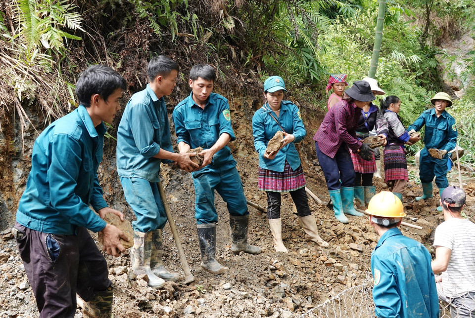 Lực lượng dân quân các xã và nhân dân tập trung khắc phục các tuyến đường bị sạt lở tại bản Đề Sủa, xã Lao Chải. (Ảnh: Tuấn Anh/TTXVN)