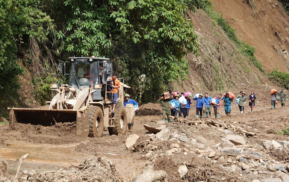 Đoàn thanh niên và dân quân xã Chế Tạo trên đường đi hỗ trợ xã Hồ Bốn. (Ảnh: Tuấn Anh/TTXVN)