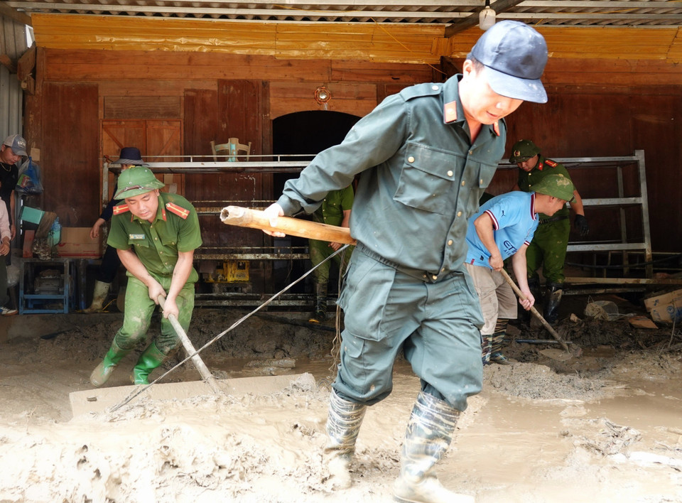 Lực lượng công an huyện Mù Cang Chải hỗ trợ các hộ dân xã Hồ Bốn dọn dẹp bùn đất sau thiên tai. (Ảnh: Tuấn Anh/TTXVN)