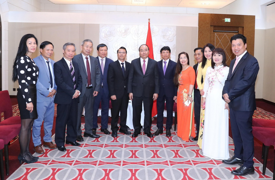 Thủ tướng Nguyễn Xuân Phúc, Chủ tịch Hội người Việt Nam tại Cộng hòa Czech Nguyễn Duy Nhiên, Chủ tịch Liên hiệp Hội người Việt Nam tại châu Âu Hoàng Đình Thắng và các đại biểu chụp ảnh chung. (Ảnh: Thống Nhất/TTXVN)