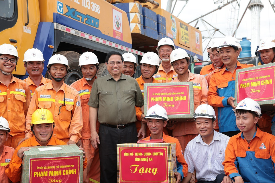 Thủ tướng Phạm Minh Chính tặng quà kỹ sư, công nhân các đơn vị đang thi công dự án đường dây tải điện 500kV mạch 3 Quảng Trạch-Phố Nối đoạn qua tỉnh Nghệ An. (Ảnh: Dương Giang/TTXVN)