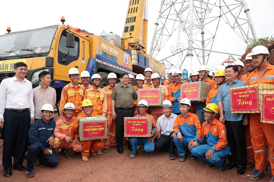 Thủ tướng Phạm Minh Chính tặng quà kỹ sư, công nhân các đơn vị đang thi công dự án đường dây tải điện 500kV mạch 3 Quảng Trạch-Phố Nối đoạn qua tỉnh Nghệ An. (Ảnh: Dương Giang/TTXVN)