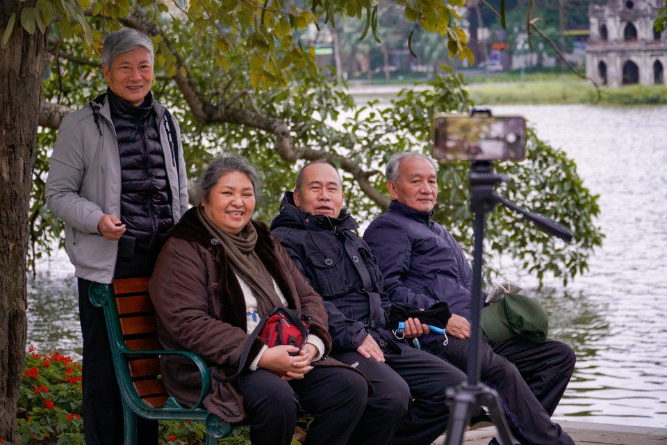 Một nhóm người cao tuổi đang vui vẻ cùng nhau ghi lại khoảnh khắc năm mới. (Ảnh: Minh Hiếu/Vietnam+)