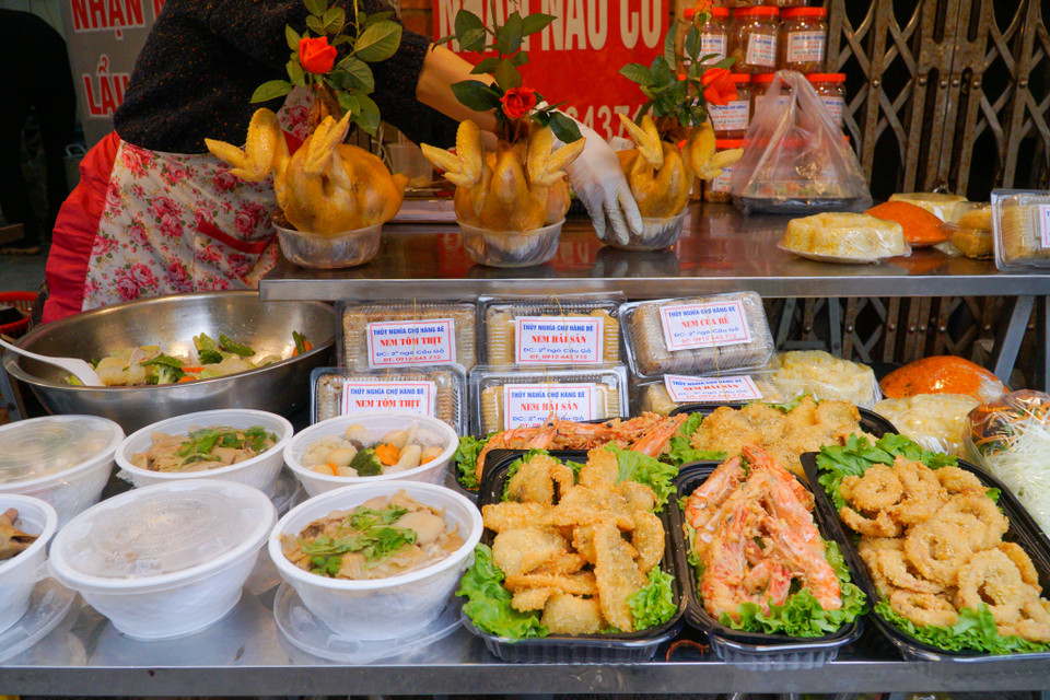 Ở khu ‘chợ nhà giàu,’ khách hàng có thể mua cả một mâm cỗ cúng được làm sẵn, với đủ các món như gà luộc, xôi gấc, canh măng, bò sốt tiêu, nem hải sản, nộm đu đủ, nem rán… (Ảnh: Minh Hiếu/Vietnam+)