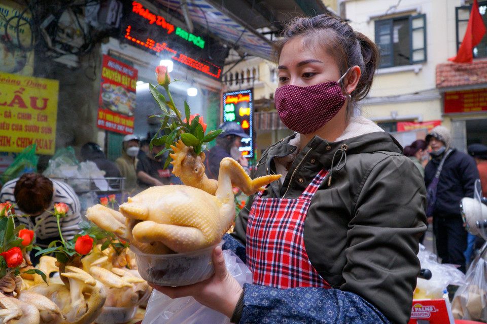 Đại diện cửa hàng đặt cỗ Hoàng Dung cho biết: ‘Trong hôm nay nhà tôi đã phải chuẩn bị 500 cặp xôi-gà và hàng chục mâm cỗ. Những ngày này, đến thở cũng không có thời gian, cửa hàng huy động hơn 10 người làm gà từ tờ mờ sáng.’ (Ảnh: Minh Hiếu/Vietnam+)