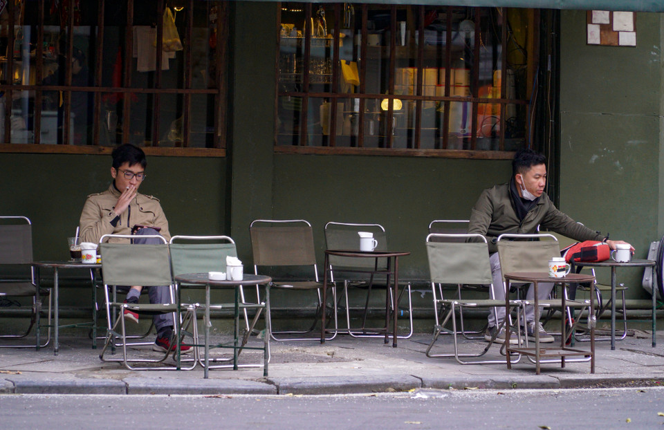 Một số người đang tận hưởng ly cà phê vào sáng đầu năm. (Ảnh: Minh Hiếu/Vietnam+)