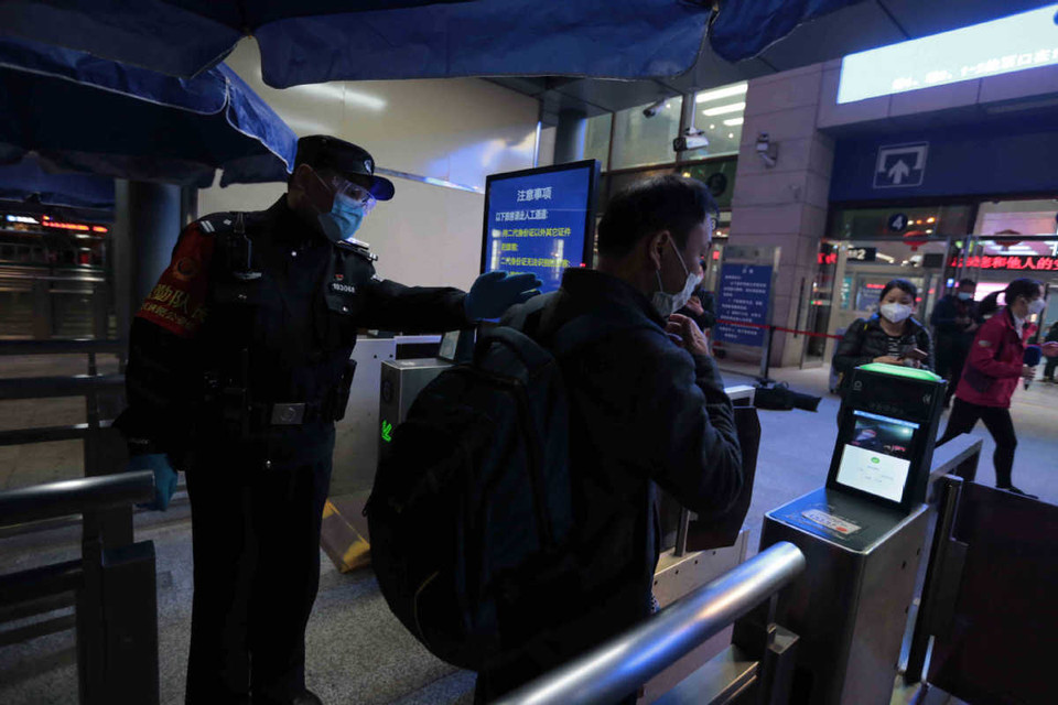 Một sỹ quan cảnh sát hướng dẫn hành khách đi vào ga xe lửa Vũ Xương ở Vũ Hán. (Nguồn: Chinadaily)