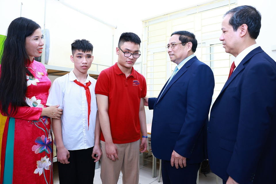 Thủ tướng Phạm Minh Chính động viên học sinh khiếm thị đang học tại Trường Phổ thông cơ sở Nguyễn Đình Chiểu. (Ảnh: Dương Giang/TTXVN)