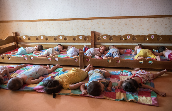Giấc ngủ trưa của các em bé trong một nhà trẻ dành cho con các công nhân một nhà máy lụa. (Nguồn: Getty)