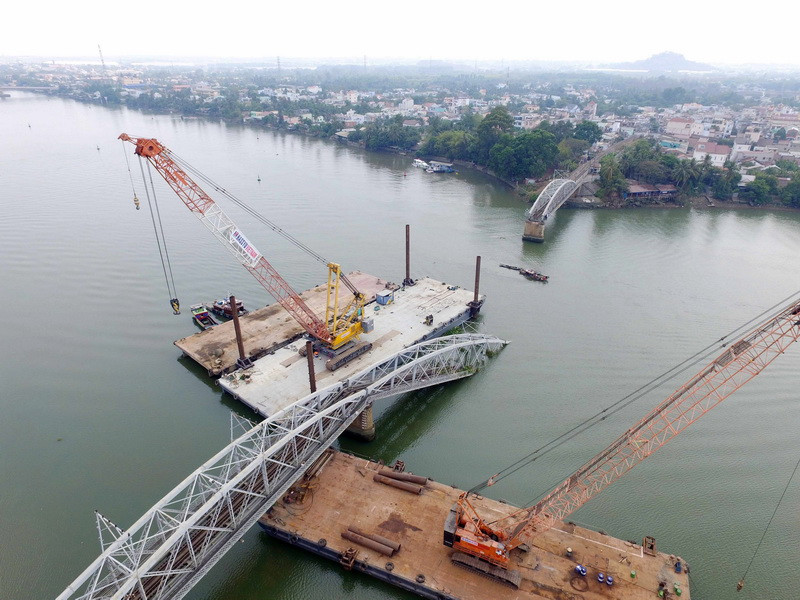 Cùng ngày, các tổ thợ lặn vẫn tiếp tục thay phiên nhau xuống đáy sông định hình những phần sắt, bêtông đang chìm dưới sông. Nhóm này cũng sử dụng các thiết bị để cắt nhỏ các phần sắt của các nhịp cầu bị chìm và phần đường ray bị kéo đổ xuống sông. (Ảnh: Mạnh Linh/TTXVN)