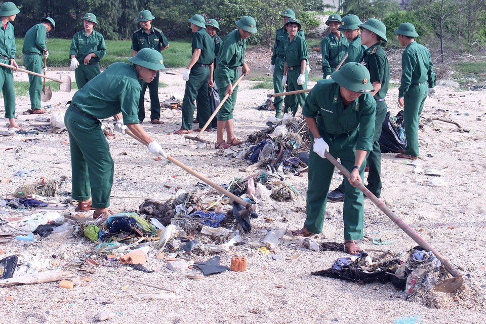 Lực lượng bộ đội tham gia thu gom rác thải dọc bãi biển. (Ảnh: Hồng Hiếu/TTXVN)