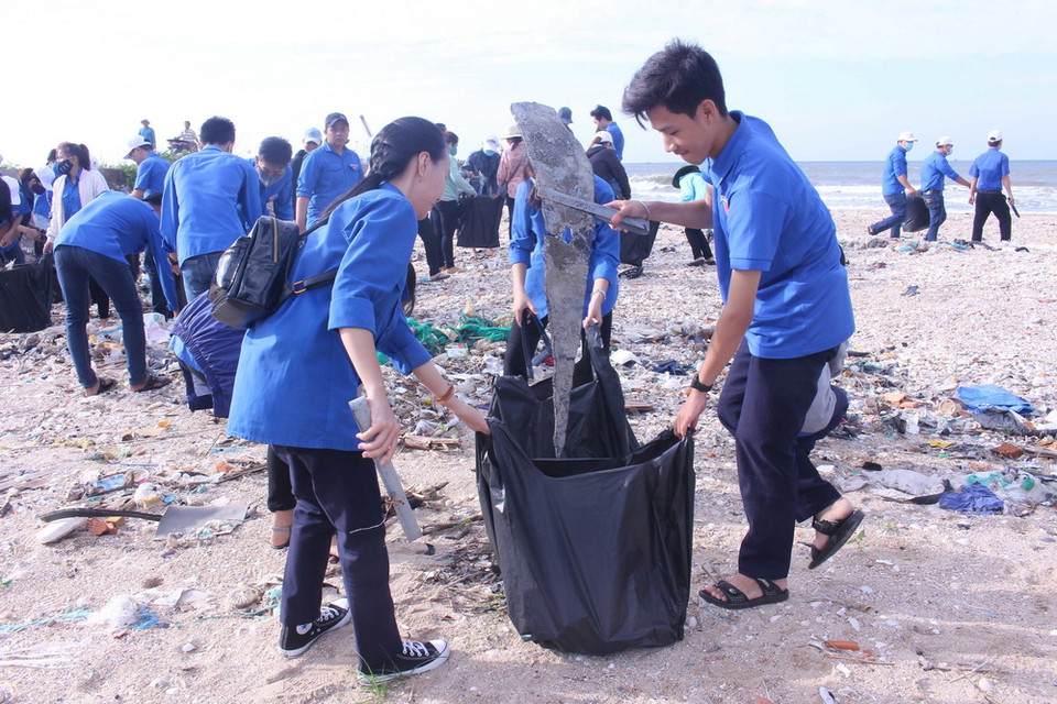 Đoàn viên, thanh niên tham gia thu gom rác thải dọc bãi biển. (Ảnh: Hồng Hiếu/TTXVN)