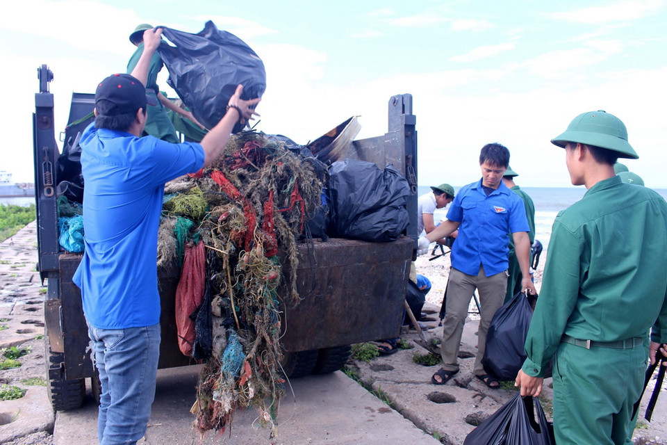 Các lực lượng tham gia thu gom rác thải dọc bãi biển. (Ảnh: Hồng Hiếu/TTXVN)