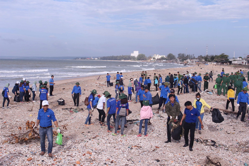 Các lực lượng tham gia thu gom rác thải dọc bãi biển. (Ảnh: Hồng Hiếu/TTXVN)
