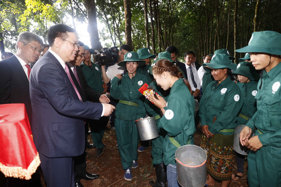 Chủ tịch Quốc hội Vương Đình Huệ tặng quà cho công nhân khai thác mủ cao su của Công ty TNHH Cao su Việt-Lào. (Ảnh: Doãn Tấn/TTXVN)