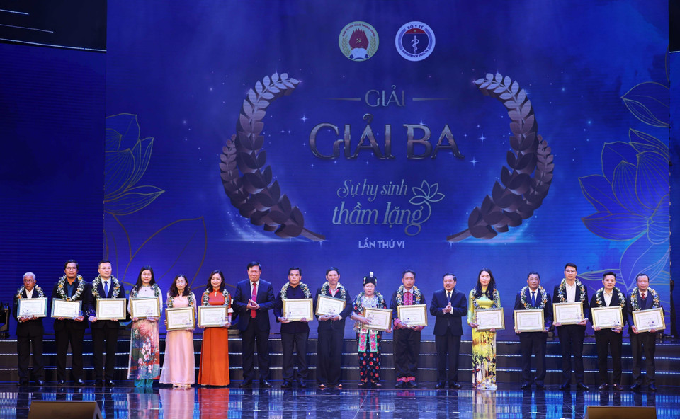 Ông Lại Xuân Môn, Uỷ viên Trung ương Đảng, Phó trưởng Ban Thường trực Ban Tuyên giáo Trung ương và ông Đỗ Xuân Tuyên, Thứ trưởng Bộ trưởng Bộ Y tế trao giải ba cuộc thi viết “Sự hy sinh thầm lặng” lần VI cho các tác giả và chứng nhận nhân vật trong tác phẩm. (Ảnh: Thống Nhất/TTXVN)