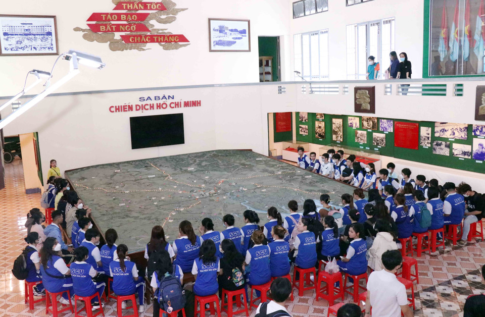 Sinh viên trường Đại học Kinh tế Thành phố Hồ Chí Minh tìm hiểu diễn biến chiến dịch Hồ Chí Minh qua mô hình sa bàn chiến dịch rộng60 m2 đặt ngay trung tâm Bảo tàng Chiến dịch Hồ Chí Minh. (Ảnh: Xuân Khu/TTXVN)