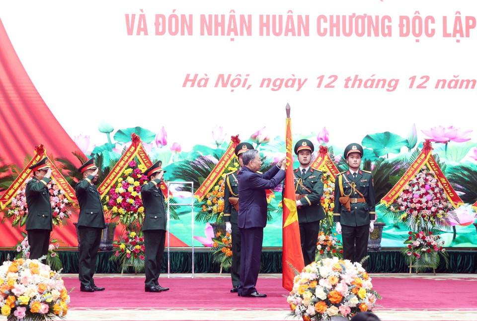 Tổng Bí thư Tô Lâm gắn Huân chương Độc lập hạng Nhất lên lá cờ truyền thống của Tổng Cục Chính trị Quân đội nhân dân Việt Nam. (Ảnh: Thống Nhất/TTXVN)