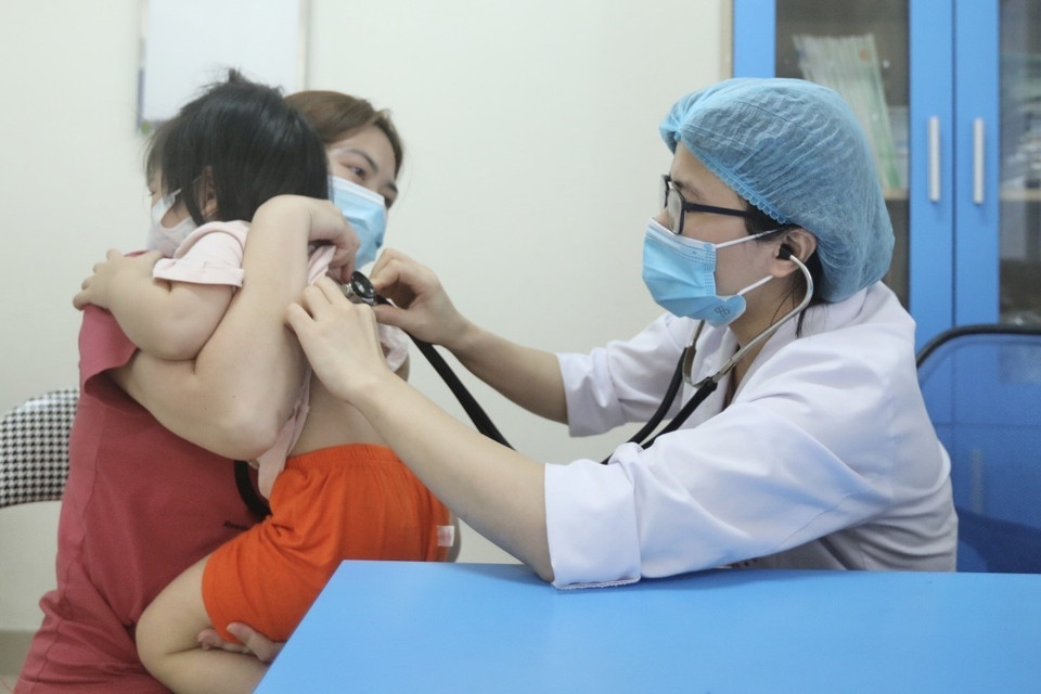 Bác sỹ Bệnh viện Bệnh nhiệt đới Trung ương khám cho bệnh nhi xuất hiện triệu chứng cúm A. (Ảnh: Minh Quyết/TTXVN)