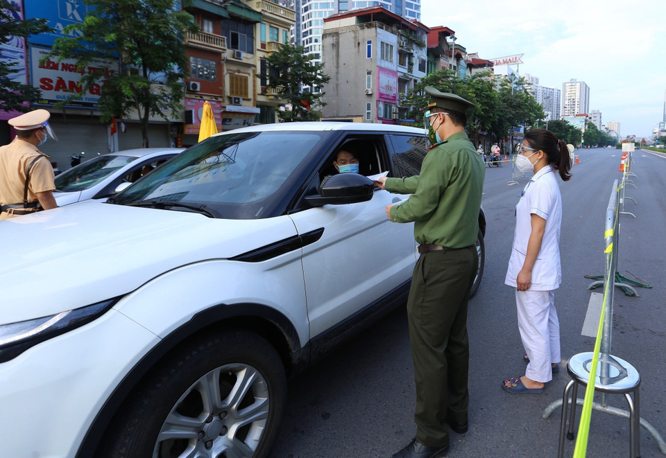 Lực lượng công an và y tế đảm bảo người có đủ điều kiện mới được di chuyển qua chốt cầu Vĩnh Tuy. (Ảnh: Hoàng Hiếu/TTXVN)