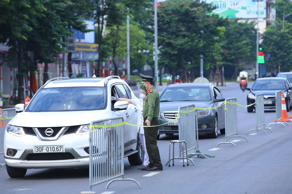 Người đi qua chốt kiểm soát cầu Vĩnh Tuy đều được đo thân nhiệt và kiểm tra giấy tờ (ảnh chụp 6h40 ngày 8/9). (Ảnh: Hoàng Hiếu/TTXVN)